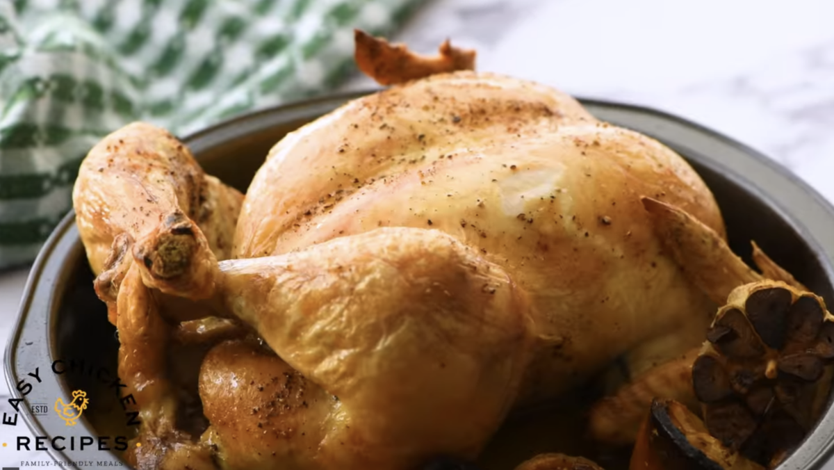 A whole roasted chicken is in a baking dish.