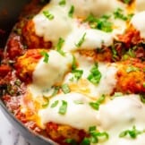 baked chicken meatballs in skillet covered with sauce and cheese