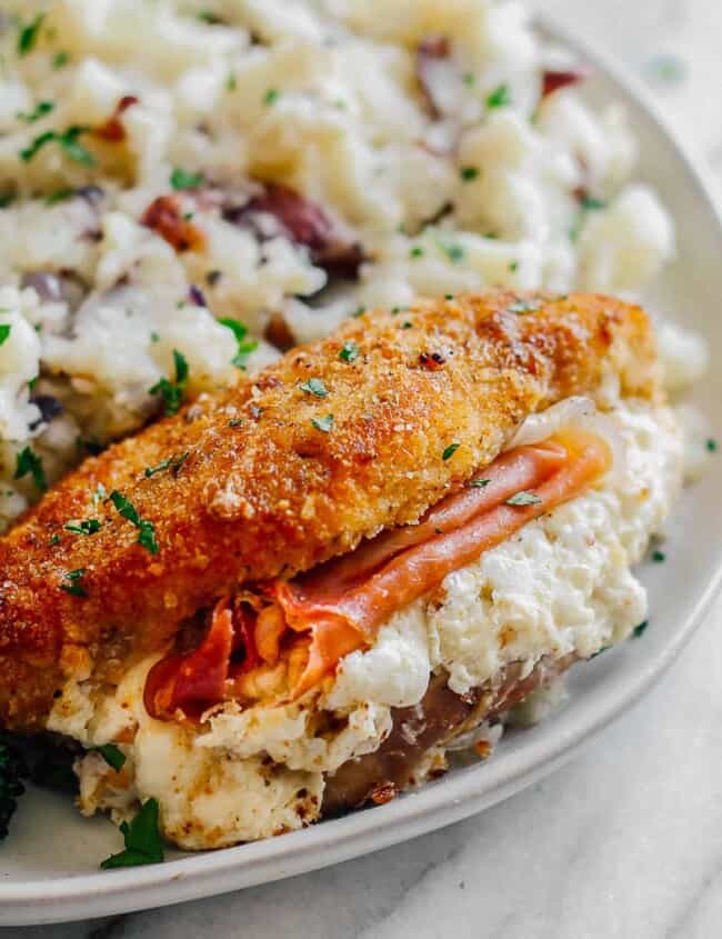 up close image of breaded chicken stuffed with prosciutto and cheese