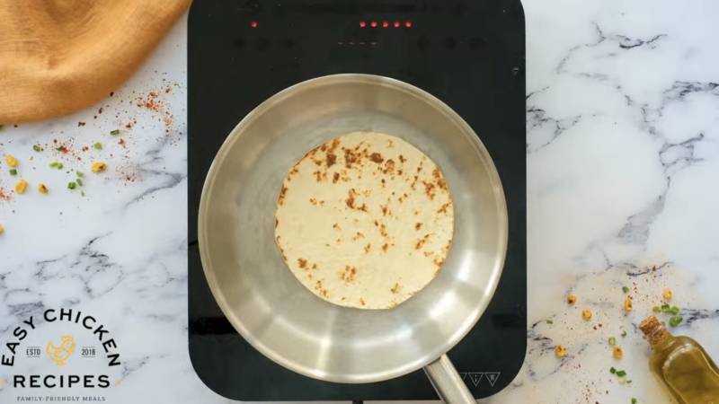 A tortilla is cooking in a pan.