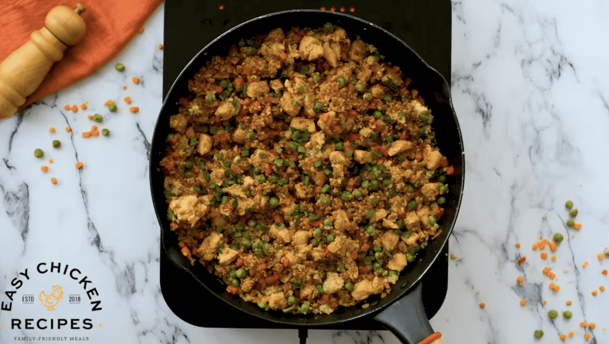Quinoa chicken fried rice is in a black skillet. 