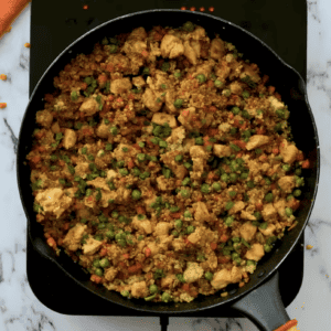 Quinoa chicken fried rice is in a black skillet.