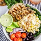 Mexican Street Corn Grilled Chicken Salad is a fiesta in a bowl! A base of lime massaged kale salad packed with black beans, cherry tomatoes, red onion and avocado. Topped with Zesty Lime Grilled Chicken and drool-worthy Mexican Street Corn!