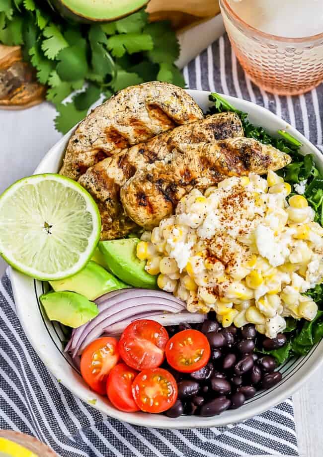 Mexican Street Corn Grilled Chicken Salad is a fiesta in a bowl! A base of lime massaged kale salad packed with black beans, cherry tomatoes, red onion and avocado. Topped with Zesty Lime Grilled Chicken and drool-worthy Mexican Street Corn!