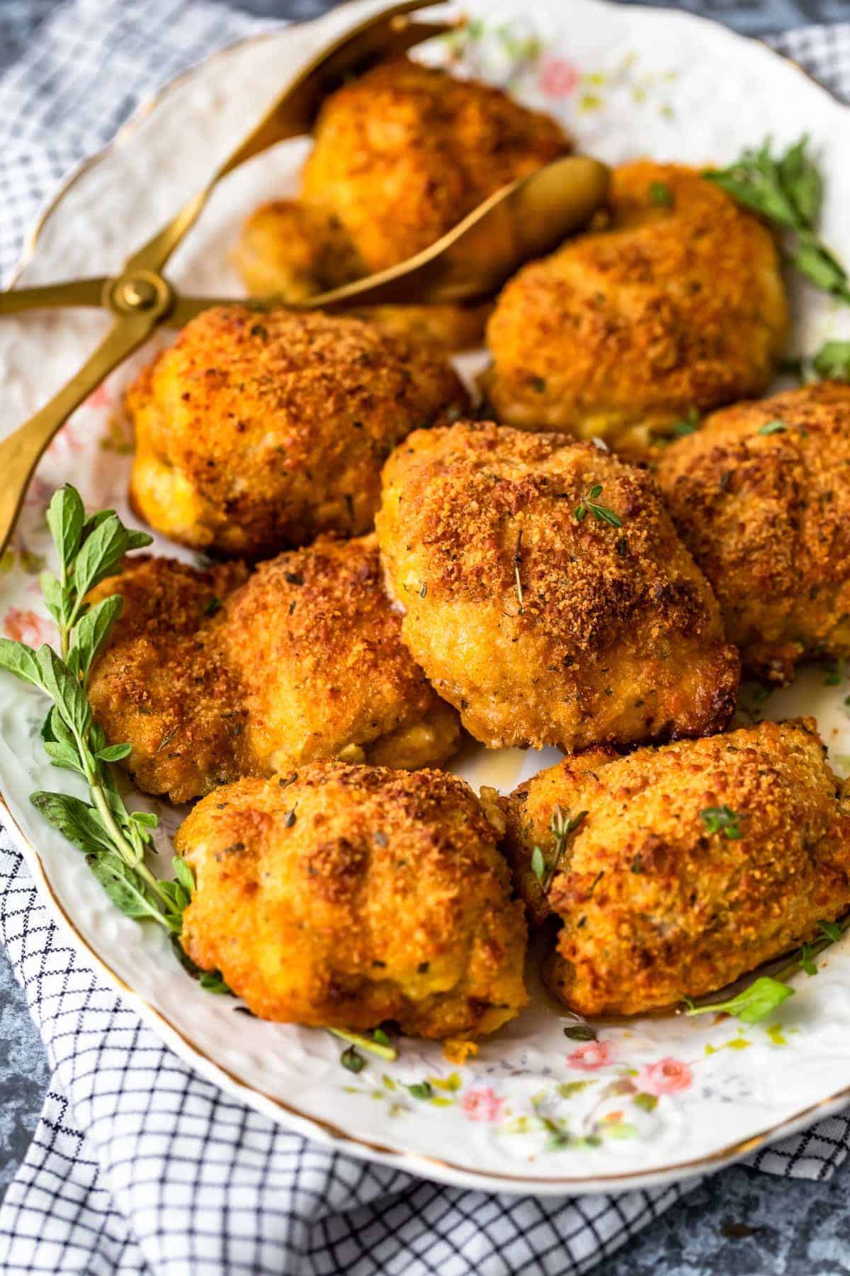 a plate of parmesan crusted chicken thighs, coated in a crispy breading