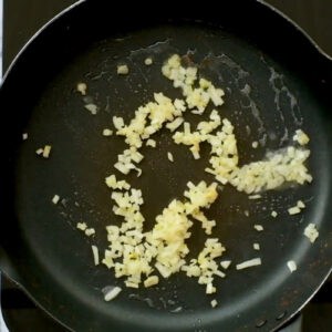 sautéeing finely chopped onion in a pan.