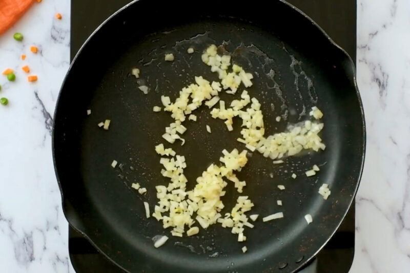 sautéeing finely chopped onion in a pan.
