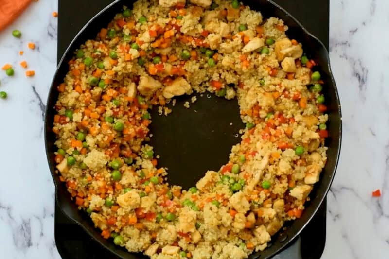 a well in the center of quinoa chicken fried rice.
