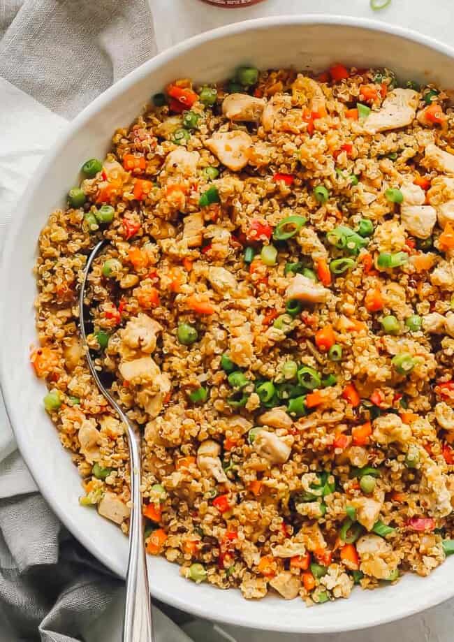 Quinoa Fried Rice is a healthy version of the take-out favorite and an easy one pan dish that’s perfect for those busy weeknights. This Quinoa Fried Rice Recipe is chocked full of veggies and chicken; making it a wholesome, filling meal the whole family will love!