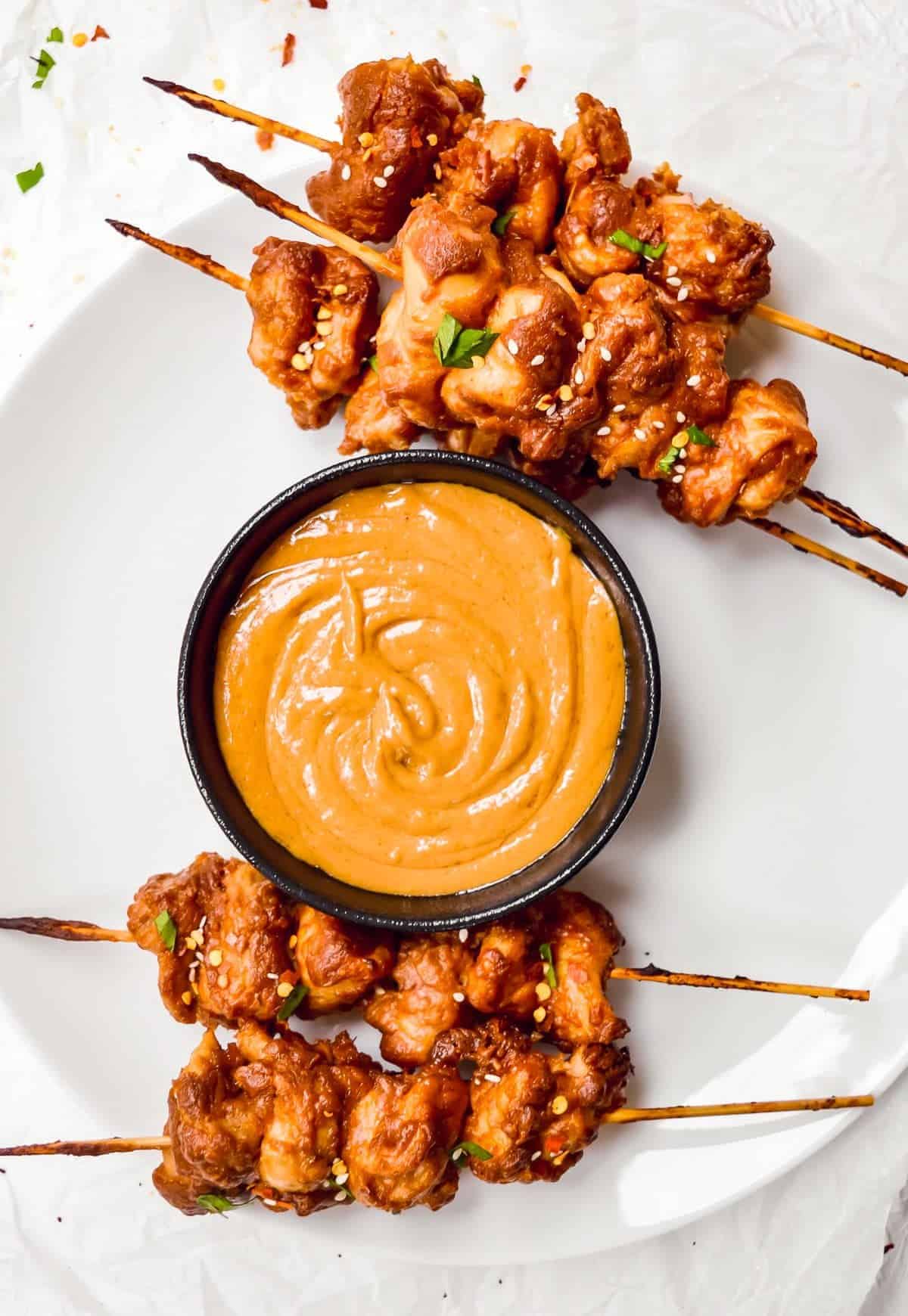 chicken skewers with spicy satay sauce overhead
