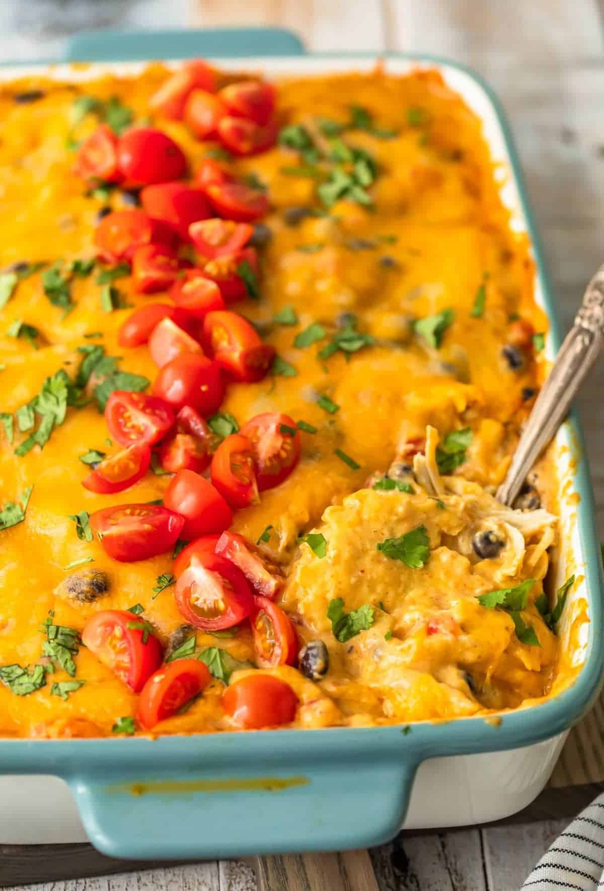 cheesy green chile chicken casserole garnished with tomatoes