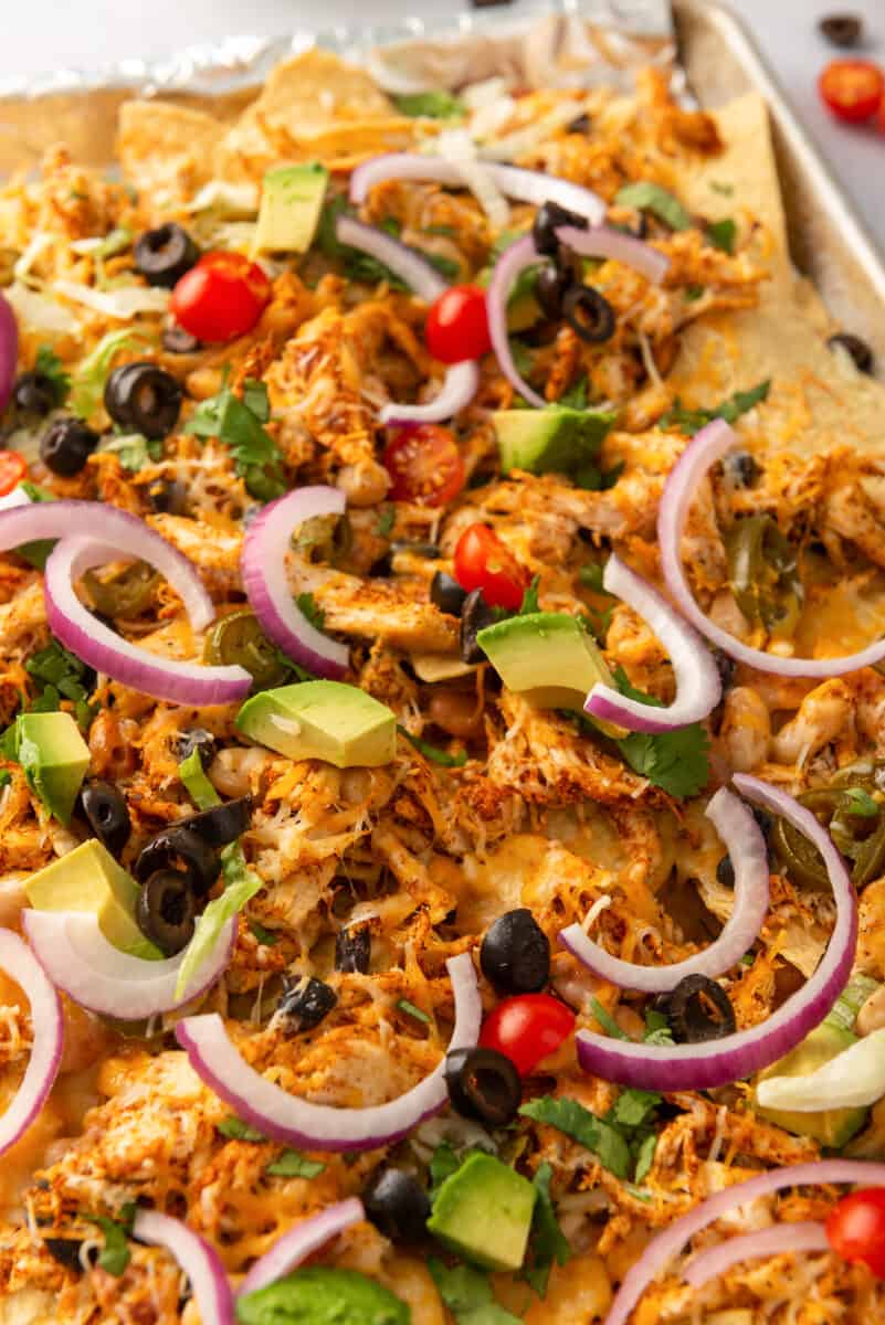 garnished mexican chicken nachos on sheet pan