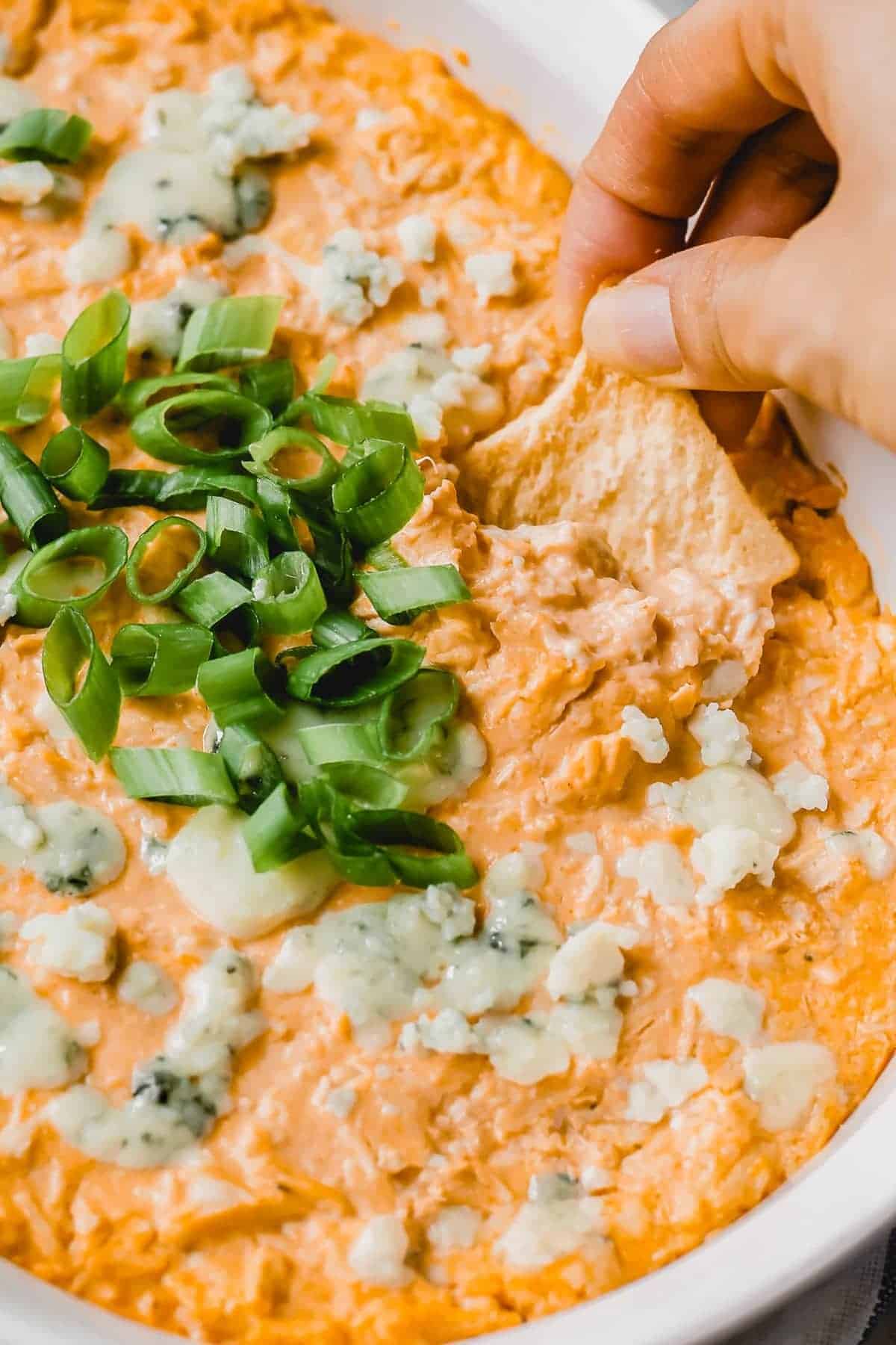 A chip scooping up some buffalo chicken dip with blue cheese