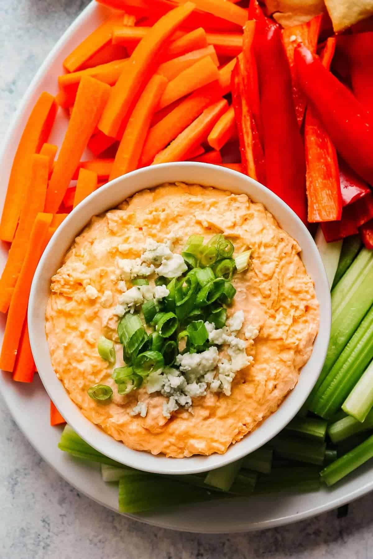 Buffalo Chicken dip with blue cheese served with a platter of vegetables