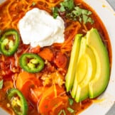 up close image of spicy Mexican Chicken soup with avocado and sour cream