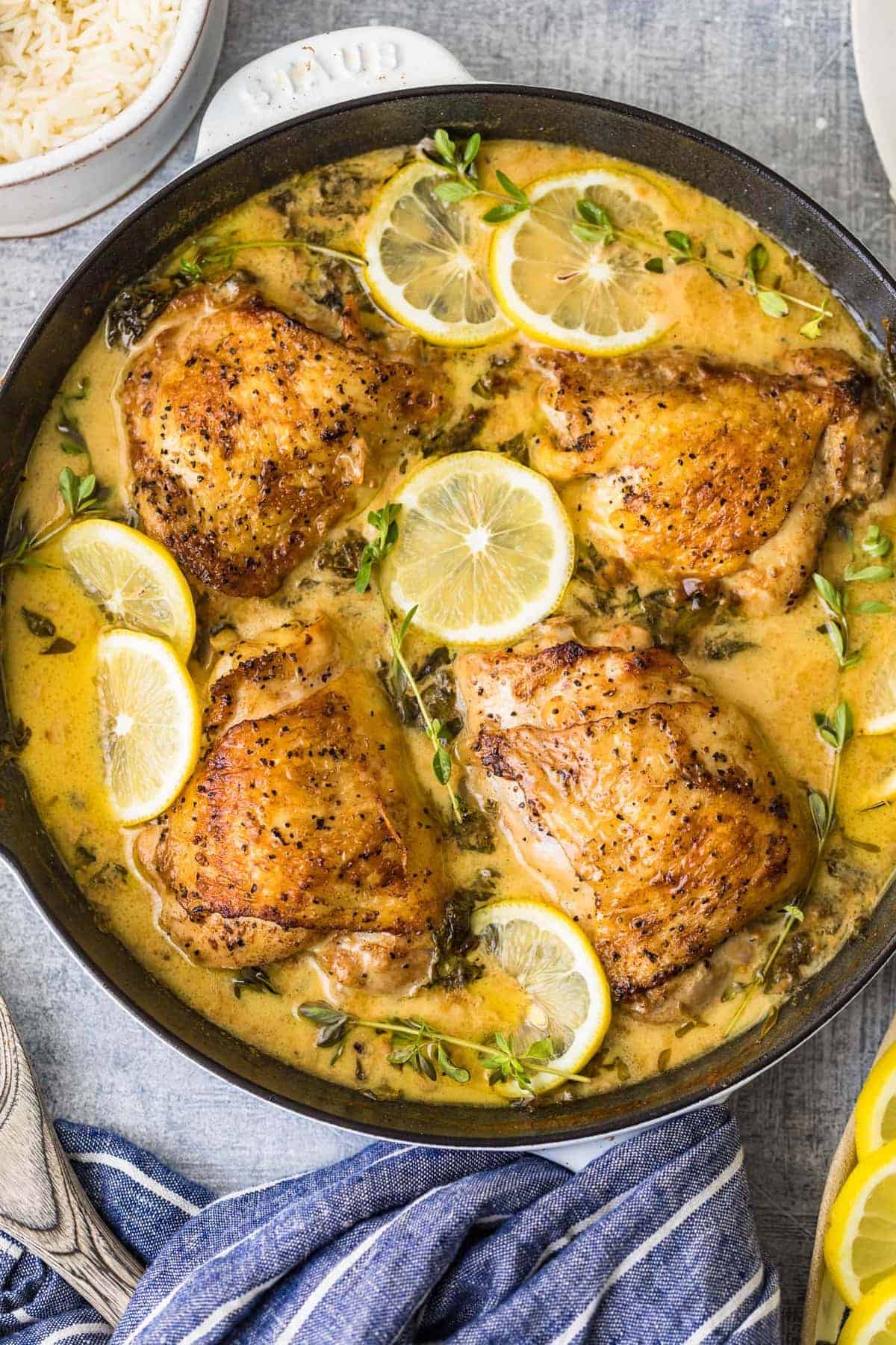 Lemon butter chicken in a skillet garnished with fresh herbs