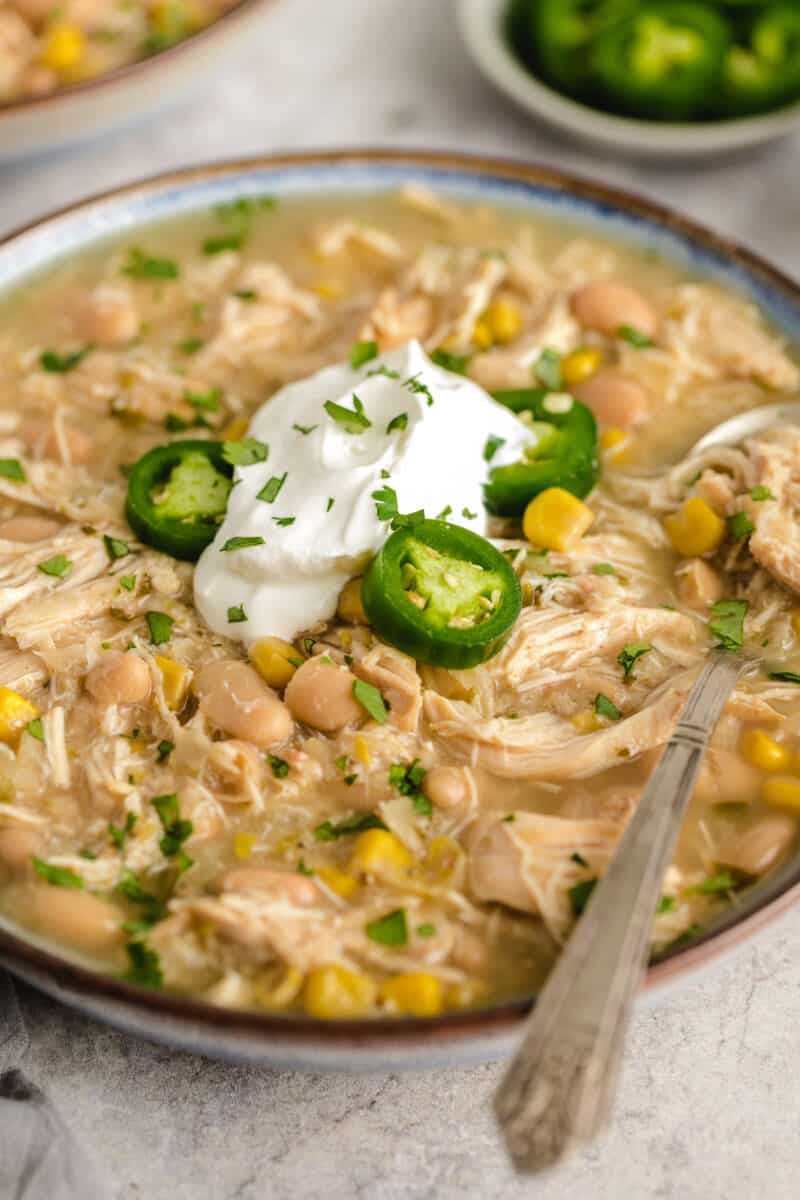 Slow cooker white chicken chili with sour cream and jalapenos.