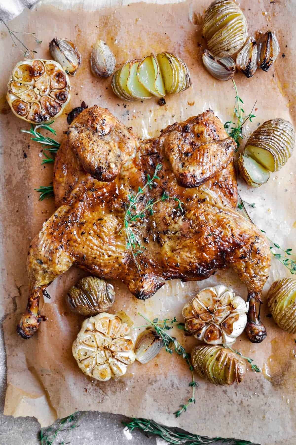 Top shot of a spatchcock chicken with potatoes and garlic