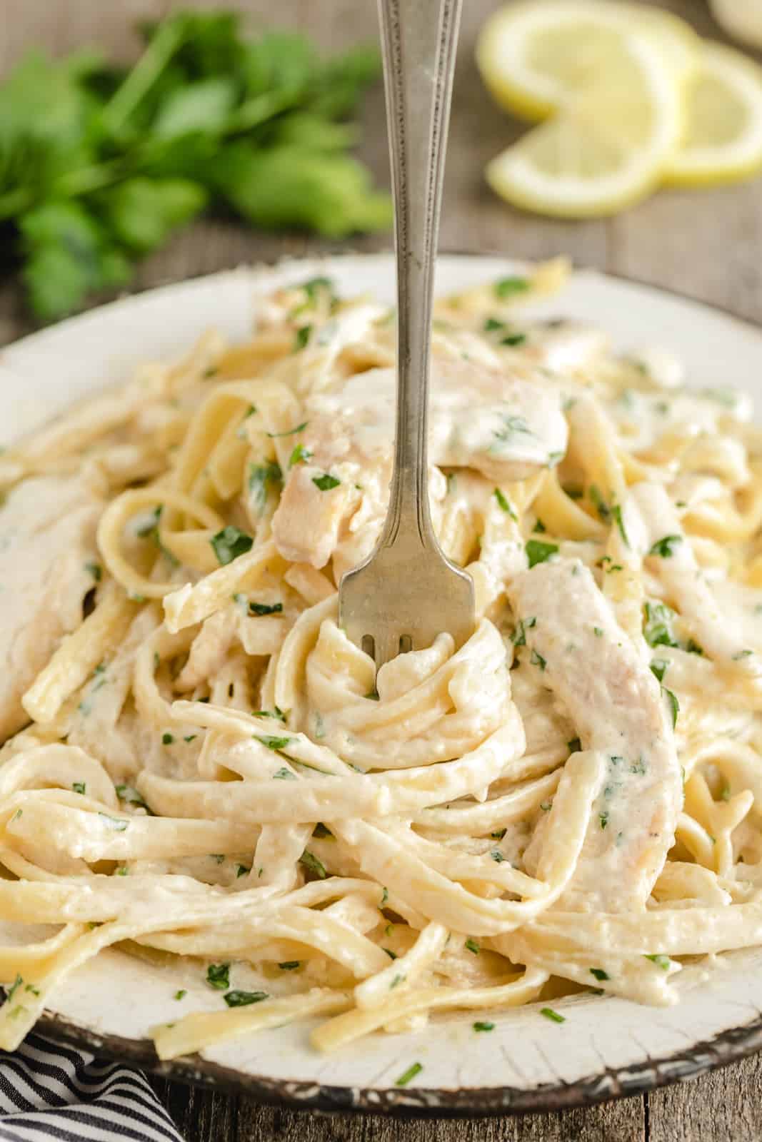 pasta tossed in alfredo sauce with chicken in a bowl