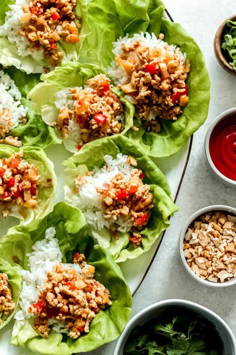 Chicken lettuce wraps presented on a plate with rice.
