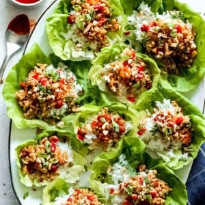 Chicken lettuce wraps with dipping sauce on a plate.