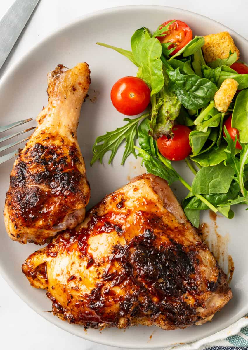 bbq chicken drumstick and thigh on plate with salad