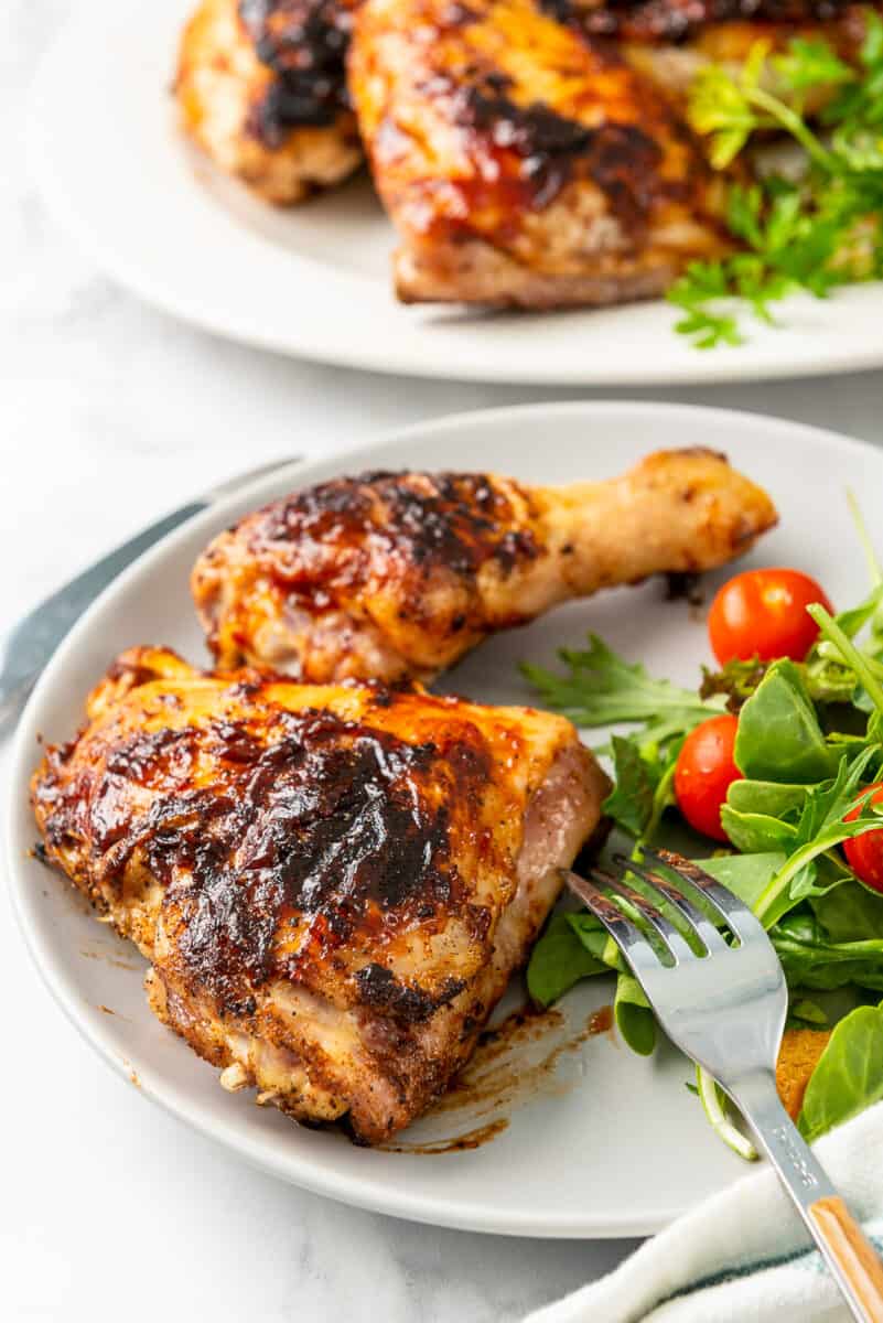 grilled bbq chicken drumstick and thigh on plate with salad