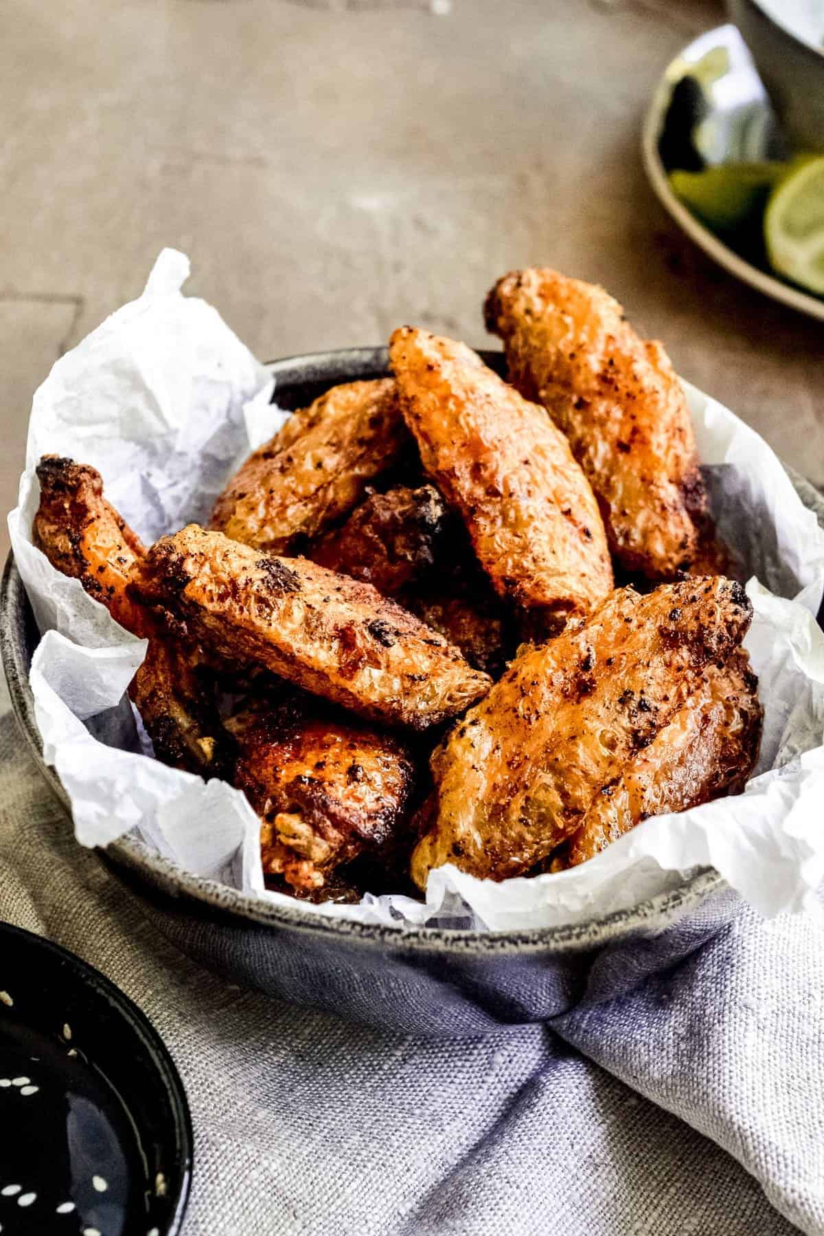 Cooked wings in a bowl with parchment paper
