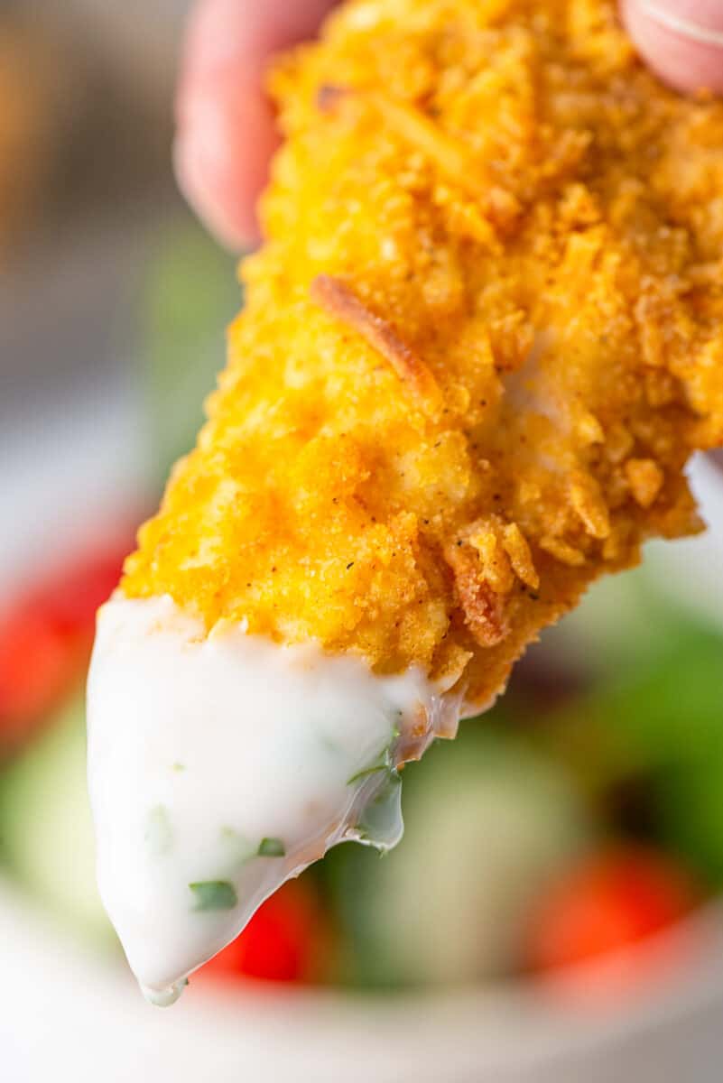 dipping chicken tender into sauce