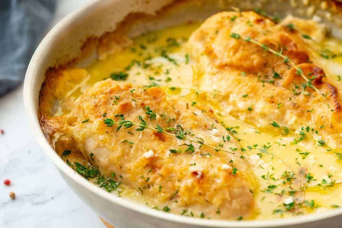 To cooked chicken breasts in a white pan