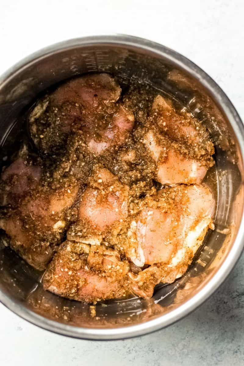 Instant Pot Jerk Chicken served in a metal bowl with sauce.