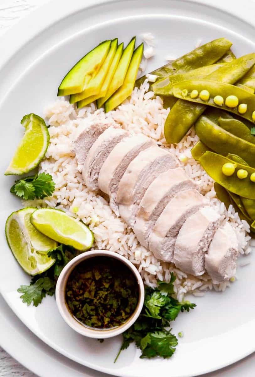 a plate with poached chicken, rice, and vegetables.