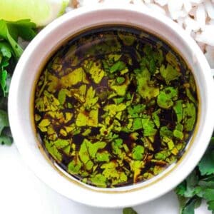 A bowl of rice with lime and cilantro, served alongside poached chicken.