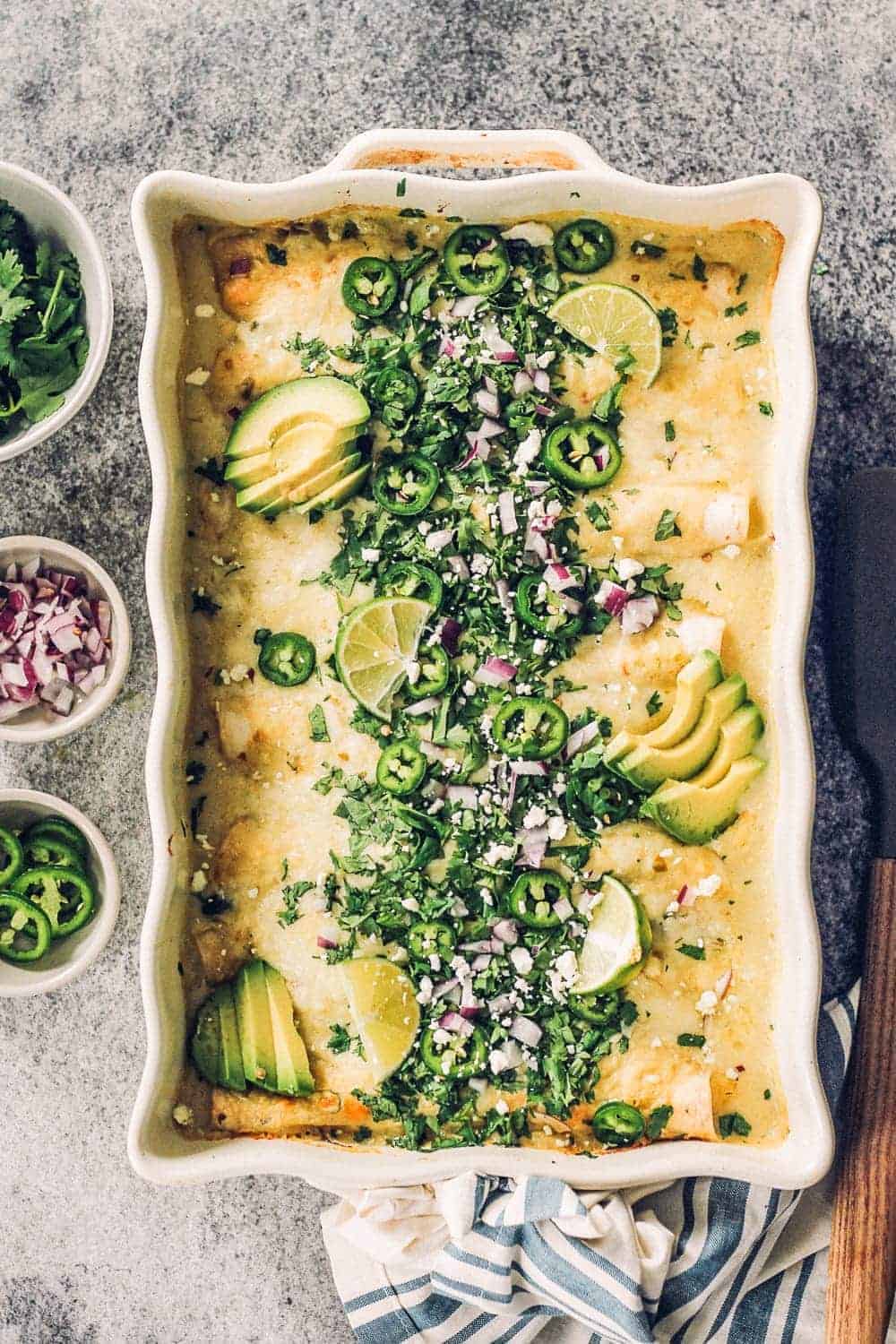 Baked Sour Cream Chicken Enchiladas topped with garnishes