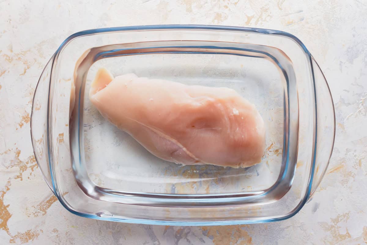 a chicken breast in a dish of water.