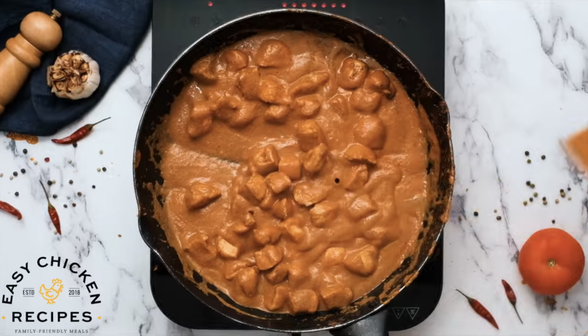 Saucy butter chicken is in a skillet. 