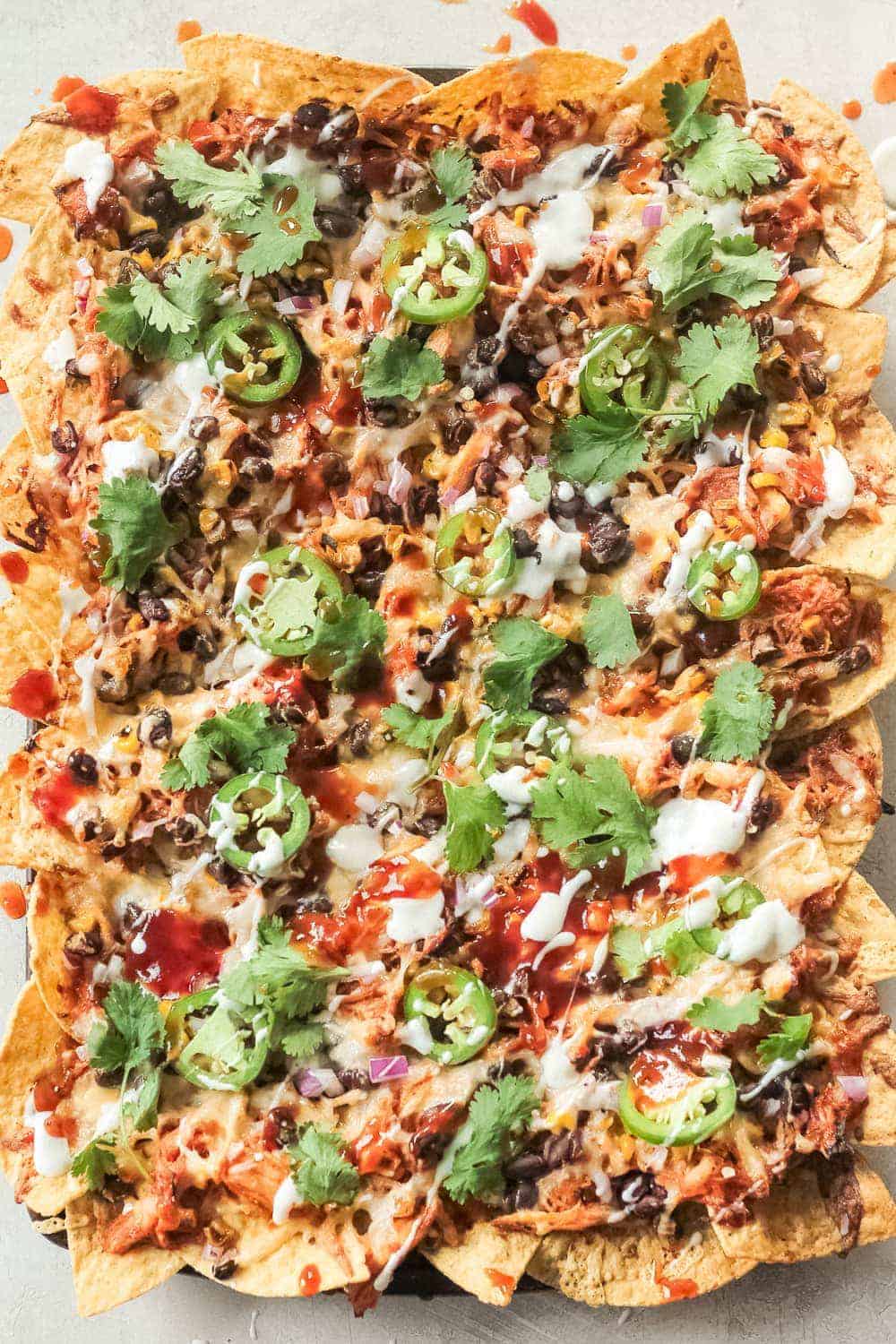 BBQ Chicken Nachos topped with cilantro and jalapenos