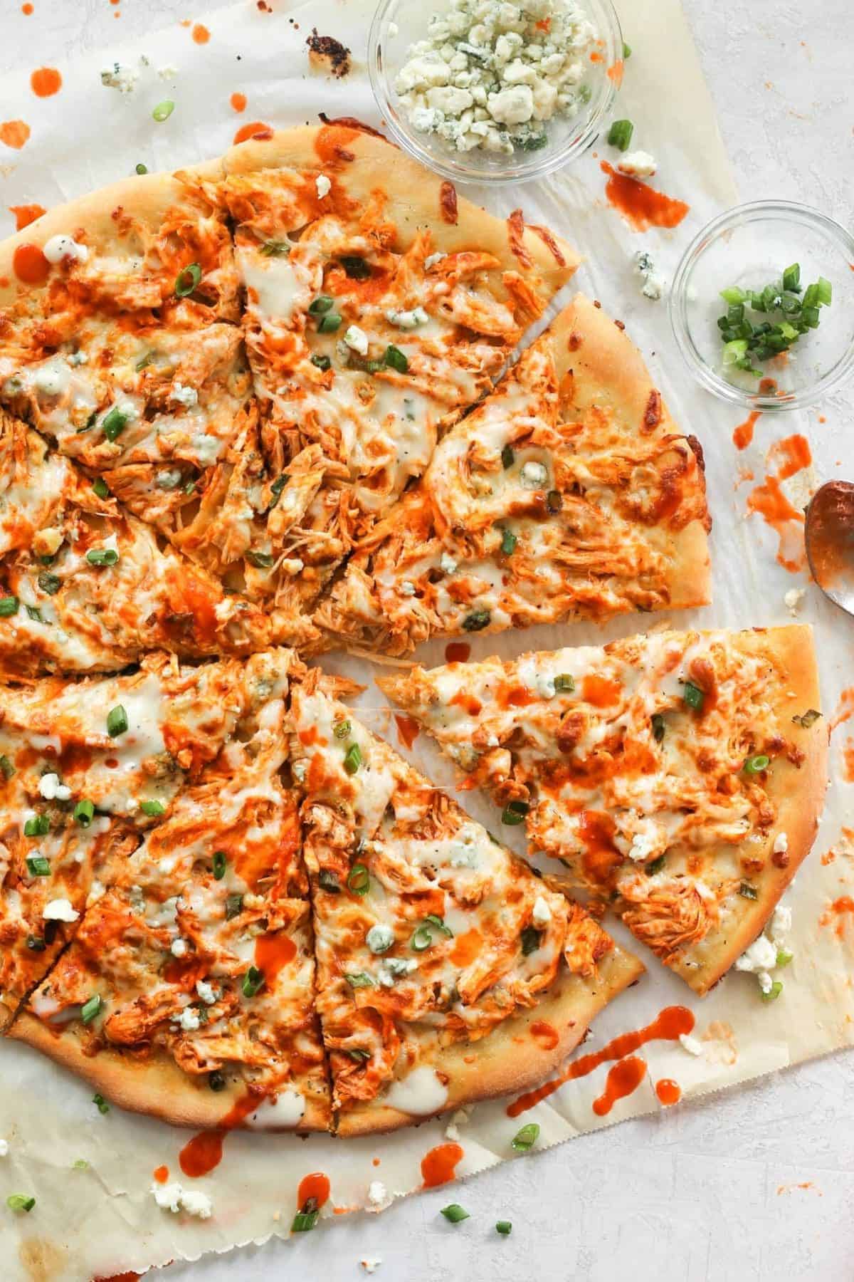 Buffalo chicken pizza on a plain surface.