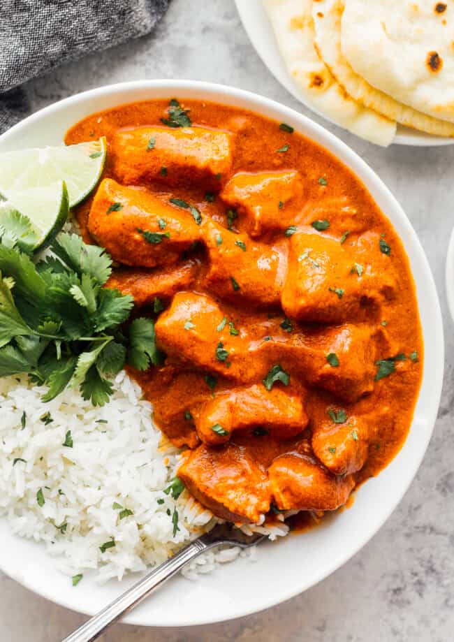 butter chicken with white rice garnished with cilantro