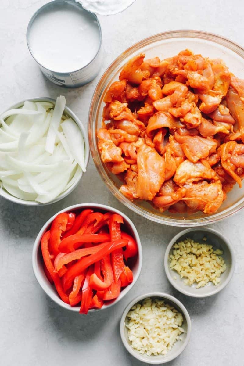 The ingredients for easy Korean chicken curry in bowls on a white background.