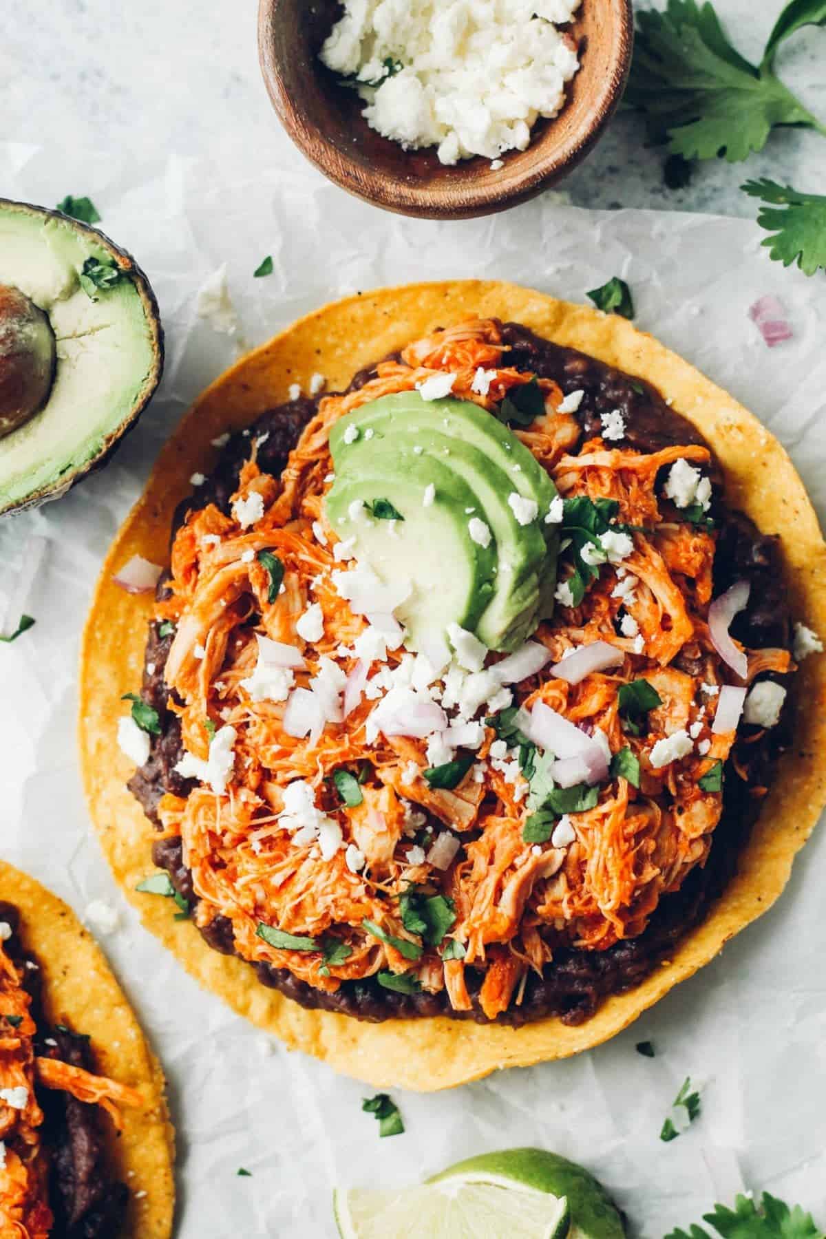 Chicken tinga served in a tostada with toppings
