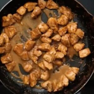 cooked marinated chicken pieces in a skillet.