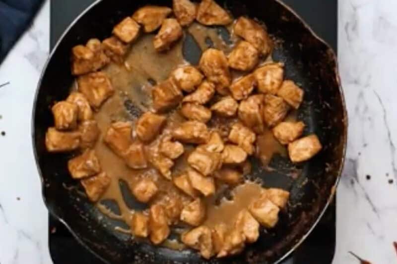cooked marinated chicken pieces in a skillet.