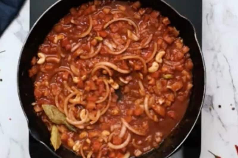 simmering butter chicken sauce in a skillet.