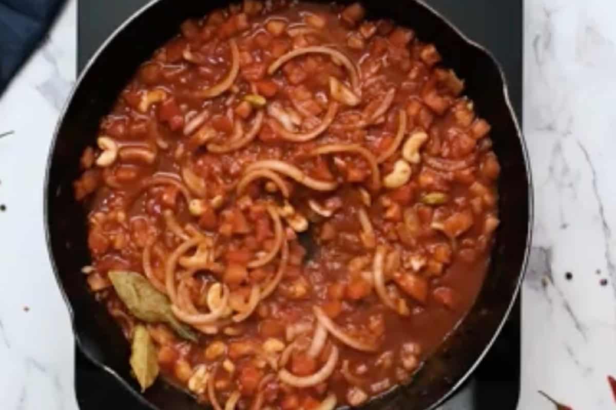 simmering butter chicken sauce in a skillet.