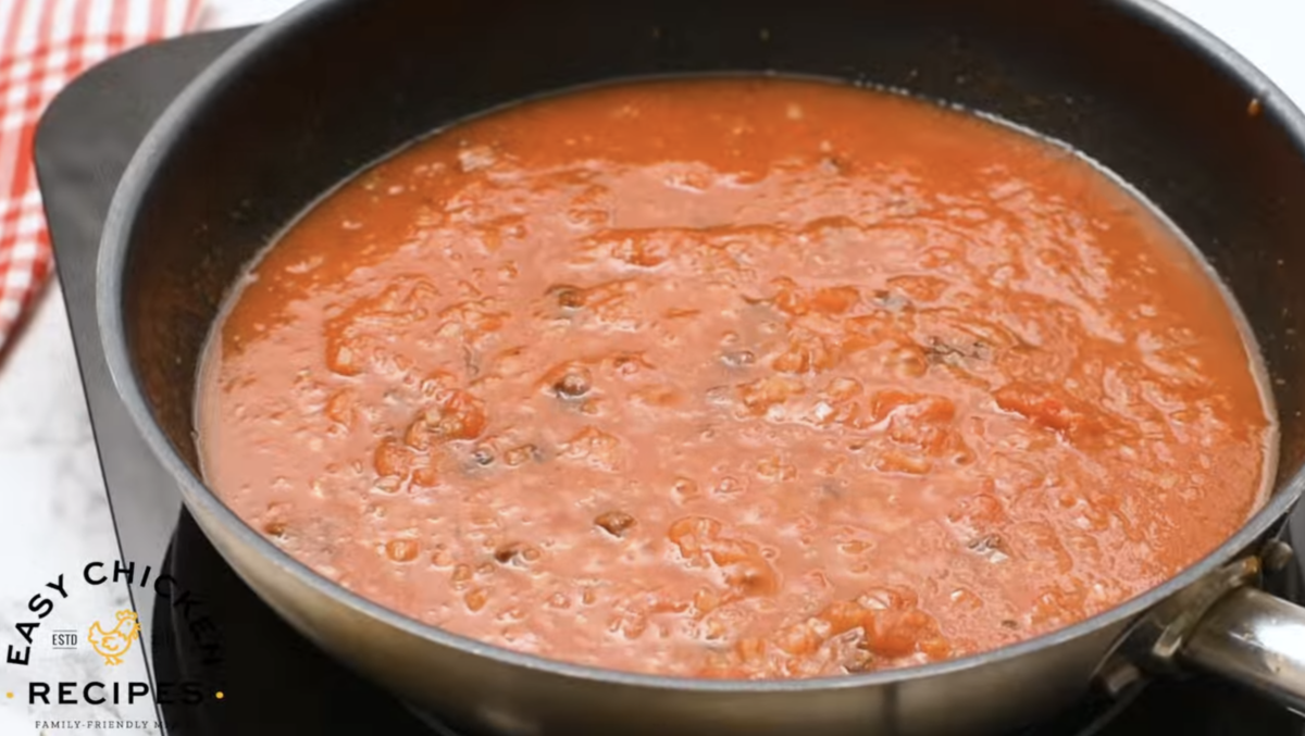 Tinga sauce is cooking in a large pot. 