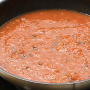 Tinga sauce is cooking in a large pot.