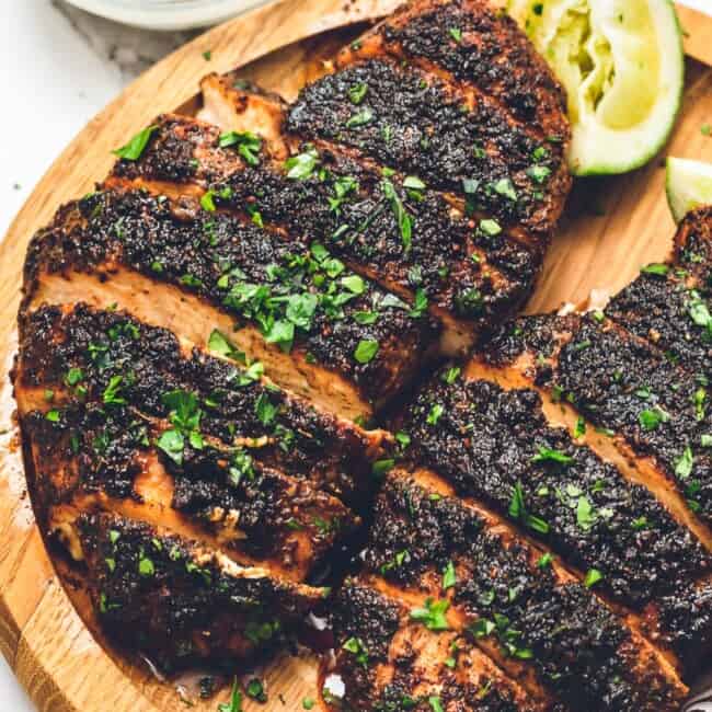 up close image of blackened chicken on wooden plate