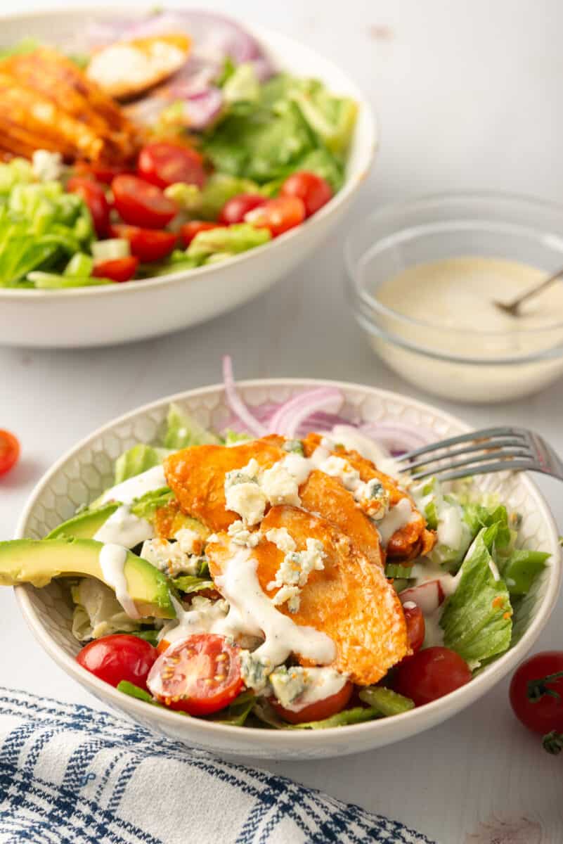 overhead image of salad topped with buffalo chicken breast