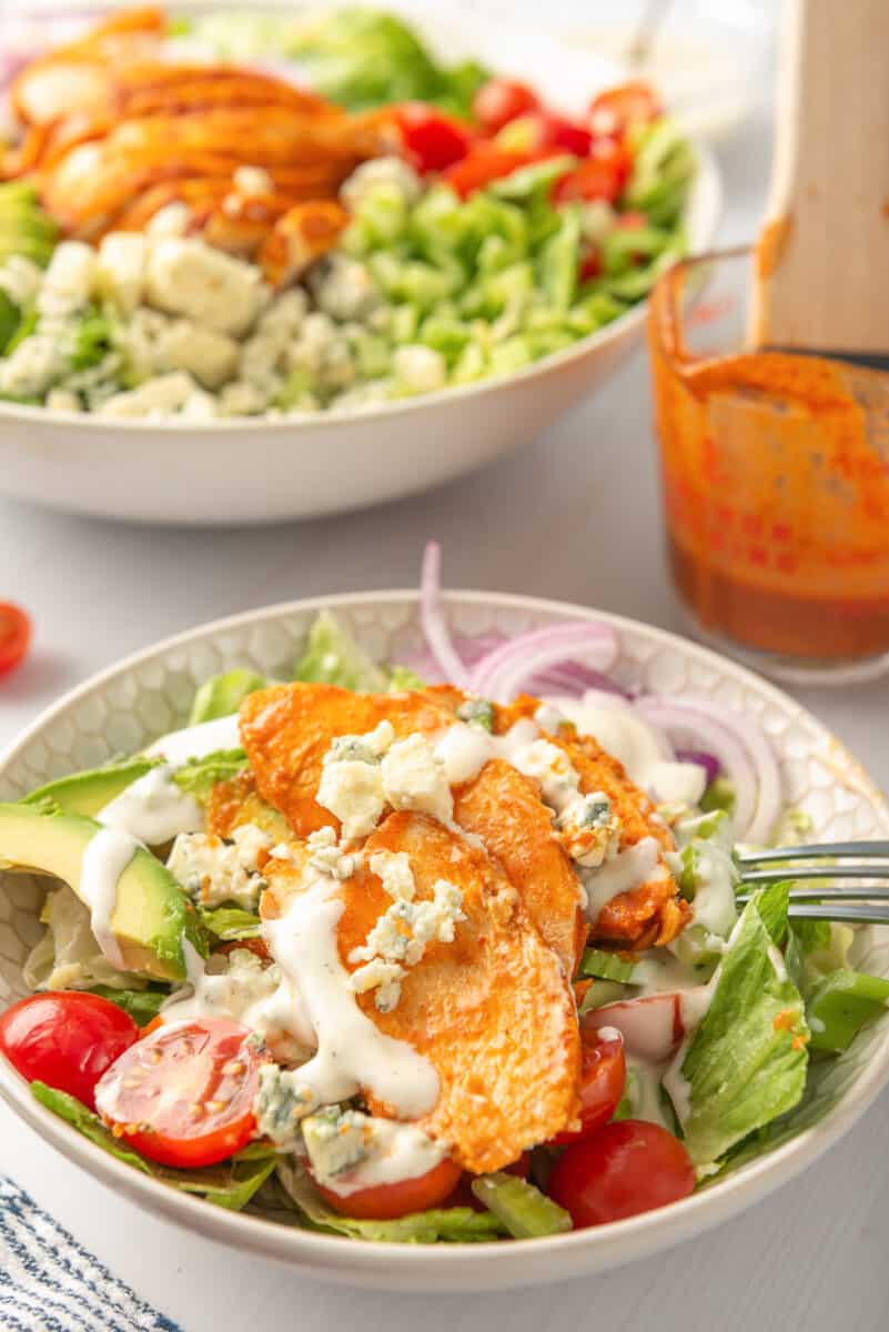 buffalo chicken salad in bowl drizzled with ranch